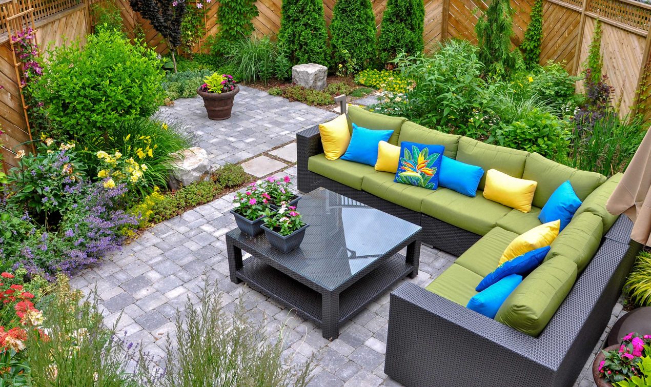 This beautiful small, urban backyard garden features a tumbled paver patio, flagstone stepping stones, and a variety of trees, shrubs and perennials.